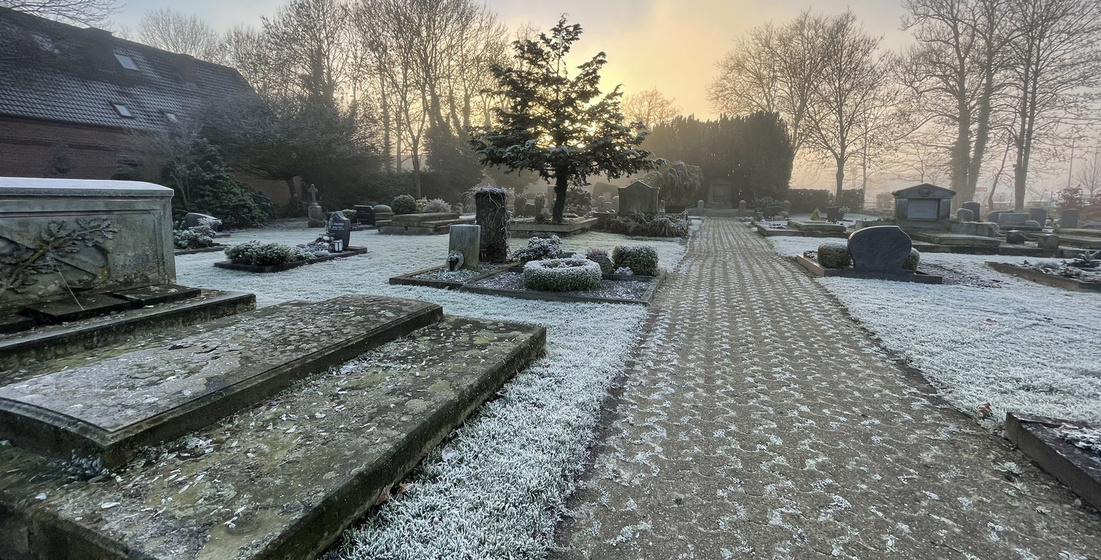 Friedhof im Winter bei Sonnenaufgang