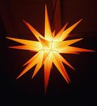 Zu sehen ist ein großer, gelb leuchtender Herrnhuter Stern.