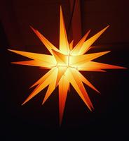 Zu sehen ist ein großer, gelb leuchtender Herrnhuter Stern.