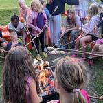 Kinder am Lagerfeur sitzend, Stockbrot machend