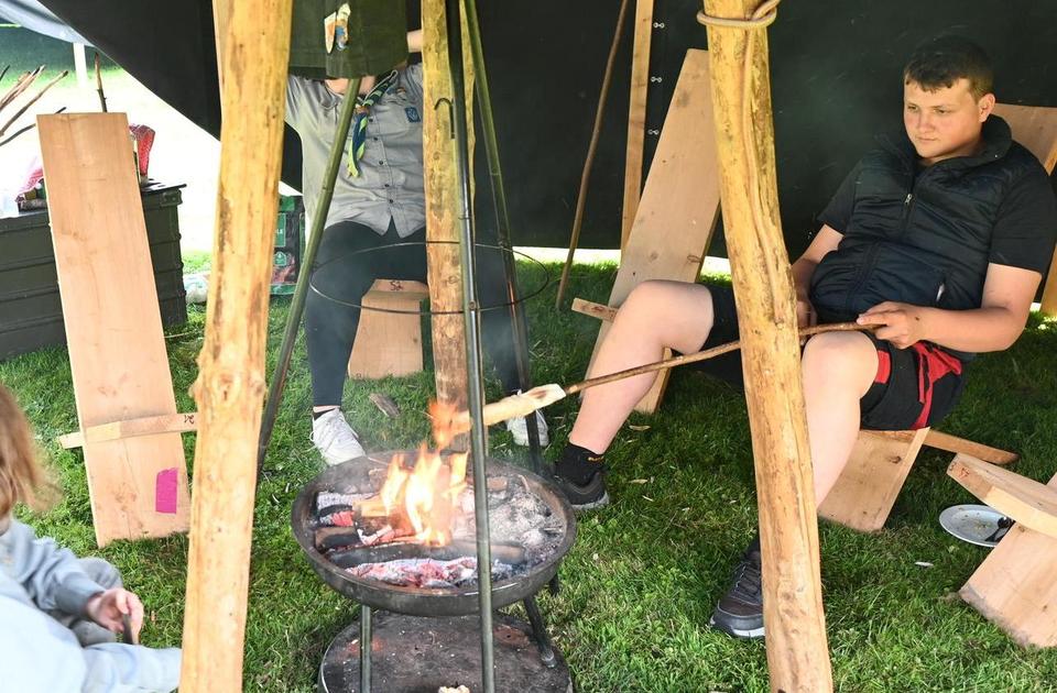 Zu sehen sind Personen an einem Lagerfeuer.