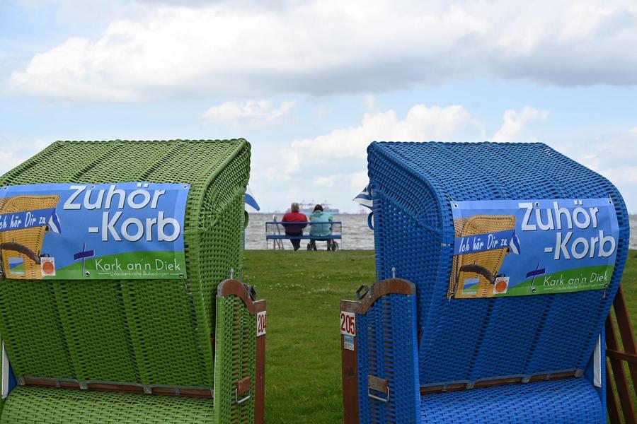 Zu sehen sind zwei Strandkörbe, auf deren Rückseiten steht "Zuhörer-Korb".