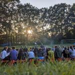 Jugendliche im Kreis auf einer Freizeit, um ein Lagerfeuer sitzend