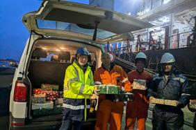 Zu sehen sind Seemänner bei der Übergabe von Christmas in a Containerbox