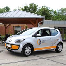 Zu sehen ist ein Auto von "Christophorus Mobil", es ist ein VW ab, der ebendiese Aufschrift trägt, um als Pflegemobil zu den Menschen nach Hause zu fahren.