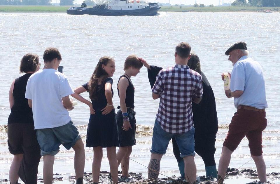 Zu sehen ist eine Taufe im Weserwasser.