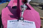 Zu sehen ist das Pappboot für die Pappbootregatta, mit dem Pokal für den zweiten Platz.