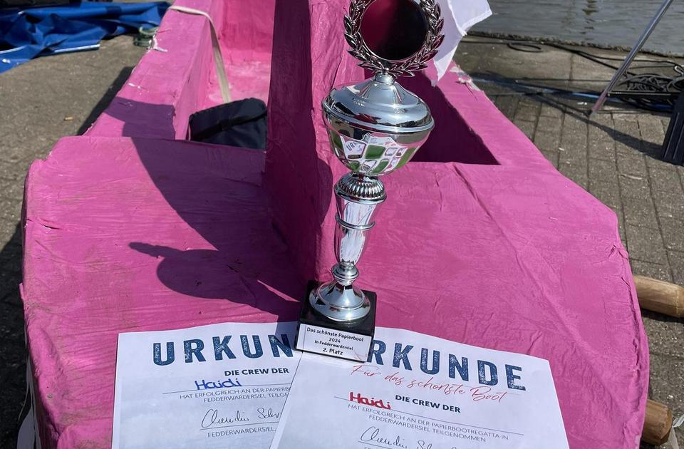 Zu sehen ist das Pappboot für die Pappbootregatta, mit dem Pokal für den zweiten Platz.