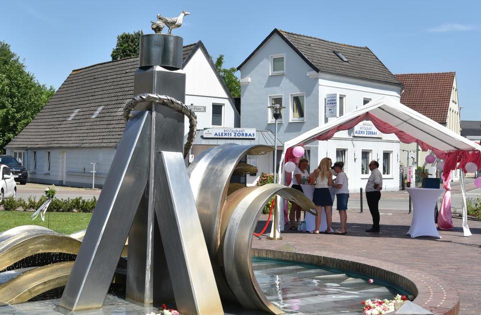 Der Brunnen auf dem Nicolai-Platz im Vordergrund und rechts im Hintergrund der Anmelde-Pavillon