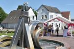 Der Brunnen auf dem Nicolai-Platz im Vordergrund und rechts im Hintergrund der Anmelde-Pavillon