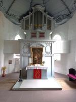 Zu sehen ist die Wilhelmi Orgel in der St.Gallus-Kirche zu Altenesch, unter der Orgelempore und ebenfalls auf dem Bild zu sehen ist der Altar.