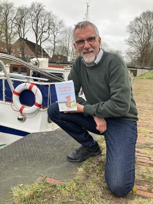 Zu sehen ist Jan Janssen, mit seinem neuen Buch "eine Handvoll Augenblicke"