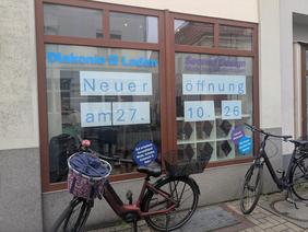 Schaufenster von SecondDesing, davor stehen zwei Fahrräder, im Schaufenster steht "Wiedereröffnug am 27.10.26".