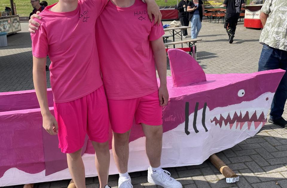 Zu sehen sind zwei Jugendliche, die an der Pappbootregatta für die Jugend der Kirchengemeinde teilgenommen haben.